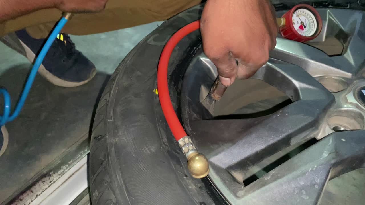 primer plano del manómetro y de las manos del hombre que comprueba la presión de los neumáticos con el medidor.