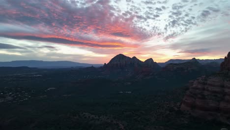 adventurous female hiker standing at the edge of a steep cliff, admiring picturesque sunset over sedona, arizona