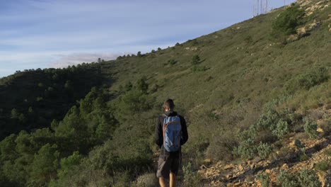 shadow of someone walking in the mountains on a sunny day with rocks on the side of the hill