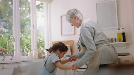 abuela feliz bailando con una niña en la cocina abuela divirtiéndose bailando con su nieta celebrando el fin de semana en casa