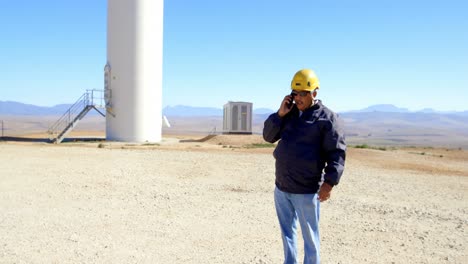 Ingeniero-Masculino-Hablando-Por-Teléfono-Móvil-En-El-Parque-Eólico-4k