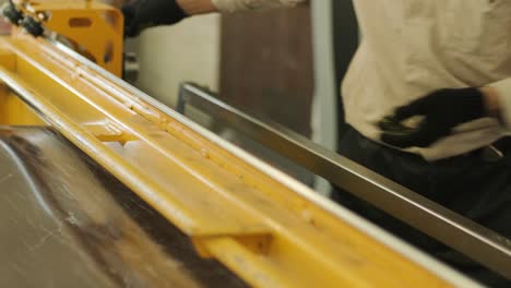 worker cuts a stainless sheet with special equipment