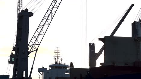 Static-Shot-Of-Huge-Crane-Unloading-Ship-At-Sunrise-Hour