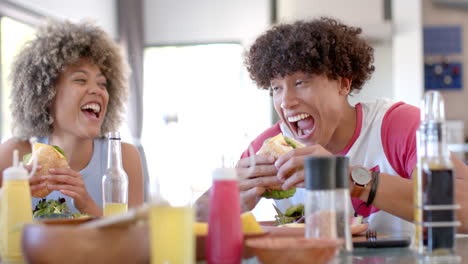 enjoying burgers and laughing, diverse friends at casual hangout