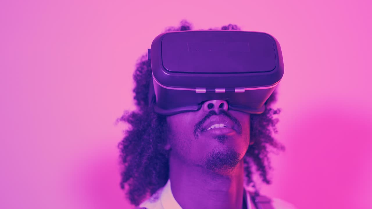 Man wearing VR headset in neon pink lighting