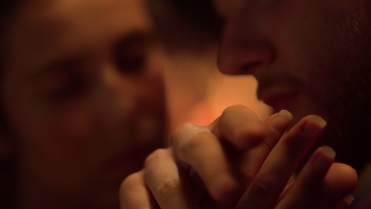 Primer plano de los dedos de una pareja tocándose junto a la chimenea. Una pareja de enamorados disfruta de sus vacaciones.