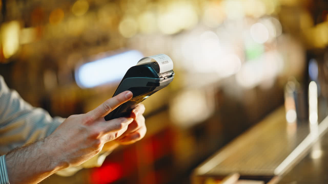 Primo piano di un uomo sconosciuto che paga il conto con carta di credito al bancone di un ristorante di sera