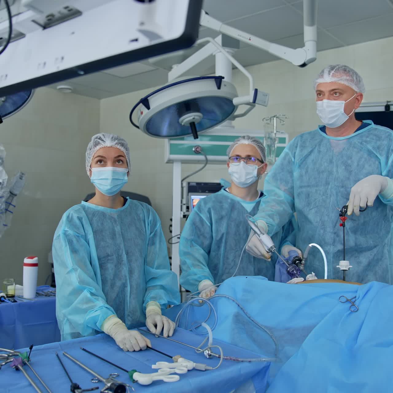 Doctors performing laparoscopic surgery. Close up of hands of surgeons team during operation uterus removal with surgical laparoscopy instruments