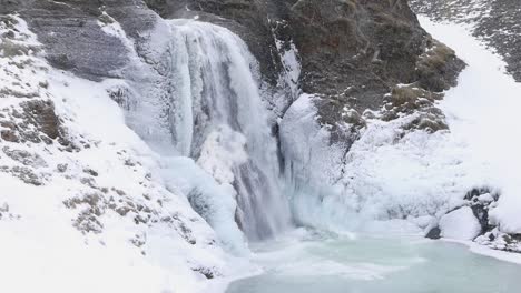 la cascada de helgufoss está cubierta de hielo. primavera temprana. islandia