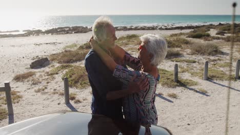 una pareja de mayores abrazándose en la playa.