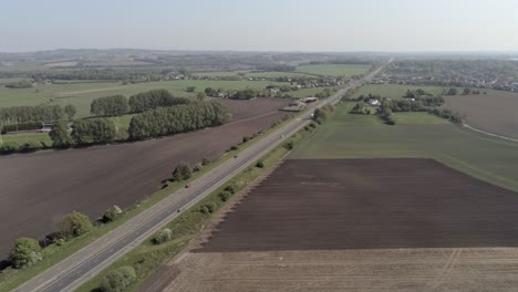 drone aerial view above british a580 east lancs highway in rural agricultural countryside pull back slow