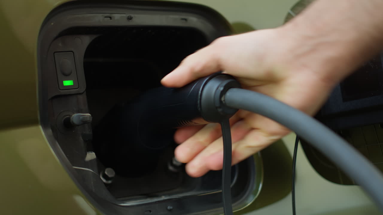 Extreme Close Up Of Driver Opening Charging Port Flap, Plugging Electric Car