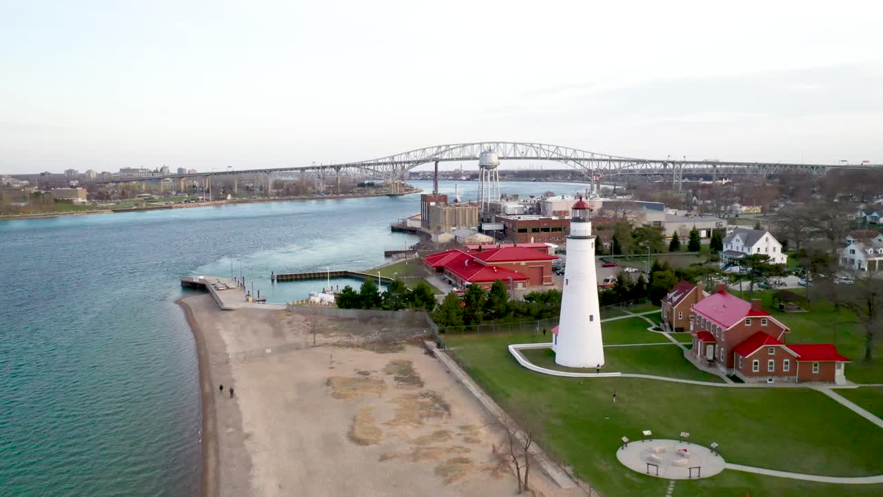 faro de fort gratiot en port huron, michigan con puente de agua azul en segundo plano video de drones avanzando