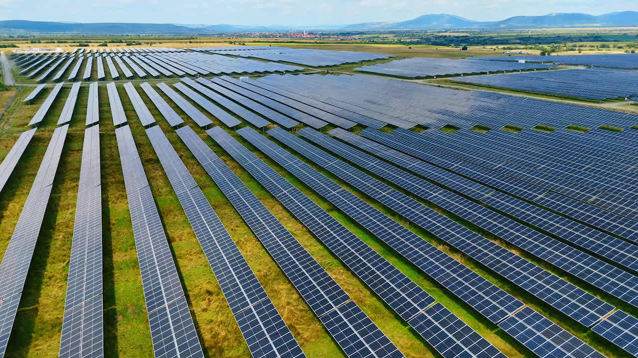 Numerous rows of modern photovoltaic panels accumulating the energy of sun. Flight above the solar panels in the countryside