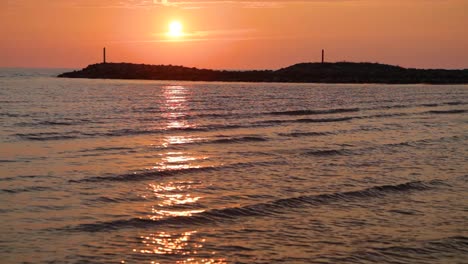 puesta de sol en el paseo marítimo por un muelle rocoso, cámara lenta