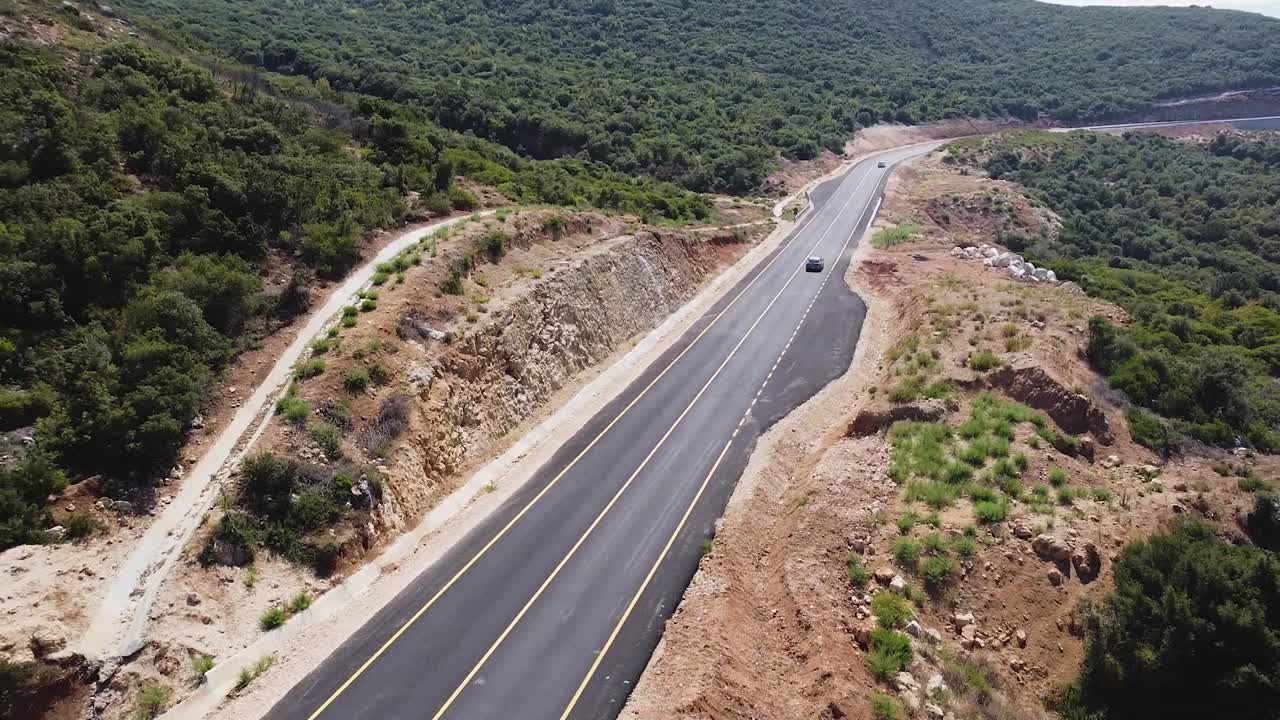 vista aérea de los coches que circulan por una nueva carretera de montaña en albania
