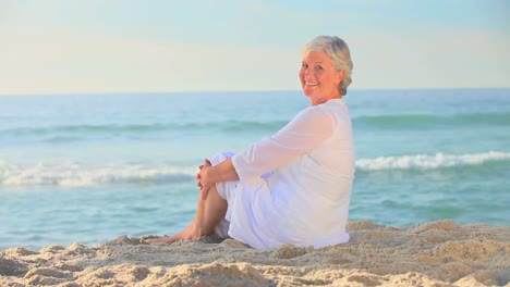 Mature-woman-sitting-on-a-beach