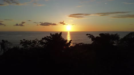 aerial drone shot capturing the fabulous uvita beach sunset in costa rica, slow pan and rotation: an enchanting orange sun casting its glow upon the sea, vibrant natural beauty with no one around