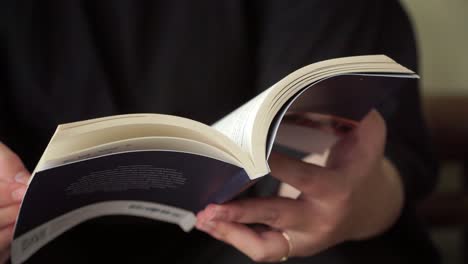 focused hands turning pages of a book, perfect for themes of education, personal growth, or quiet lifestyle
