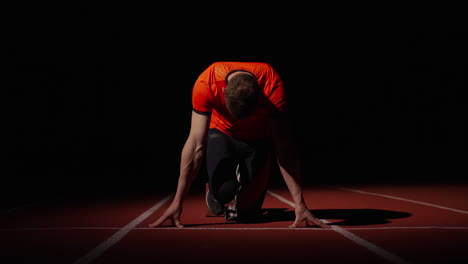 sprinter preparing for start at night