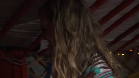 blonde european hippy woman walking inside yurt to open door, stepping outside