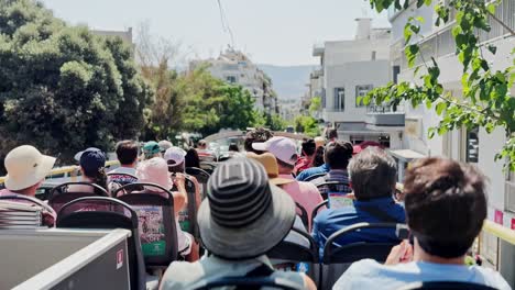 tourists on an open-top sightseeing bus in a city, athens, greece