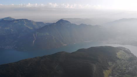 Aerial-flight-around-the-summit-of-Niederbauen-Chulm-on-a-summer-morning-in-the-Swiss-Alps-with-a-view-of-Mythen,-Rigi,-Burgenstock,-Pilatus-and-cliffs-above-Lake-Lucerne