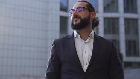 un hombre de negocios exitoso sonriente de pie al aire libre cruzando las manos en la plantilla del pecho
