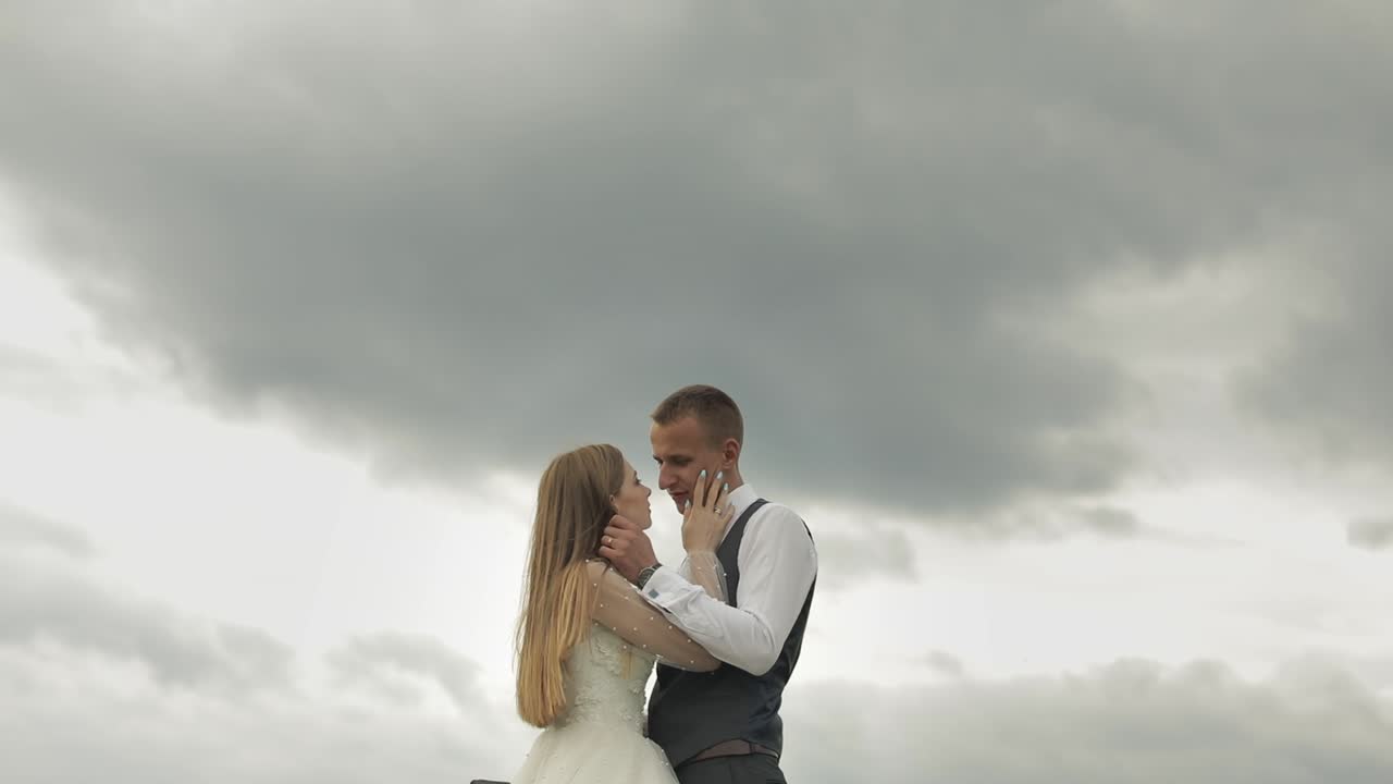 Brudgom og brud sammen mod en himmelbaggrund. Bryllupspar. Lykkelig familie.