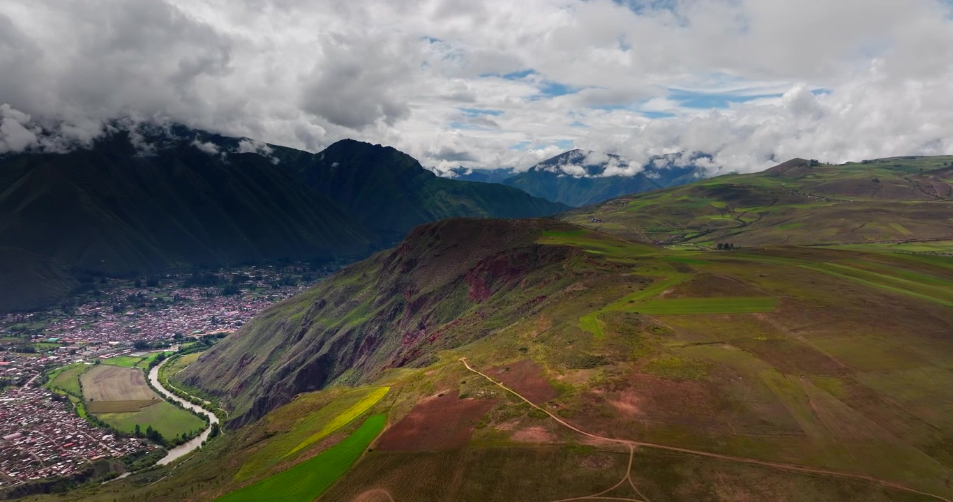Veduta aerea di una città, un fiume e le circostanti montagne delle Ande nella Valle Sacra del Perù