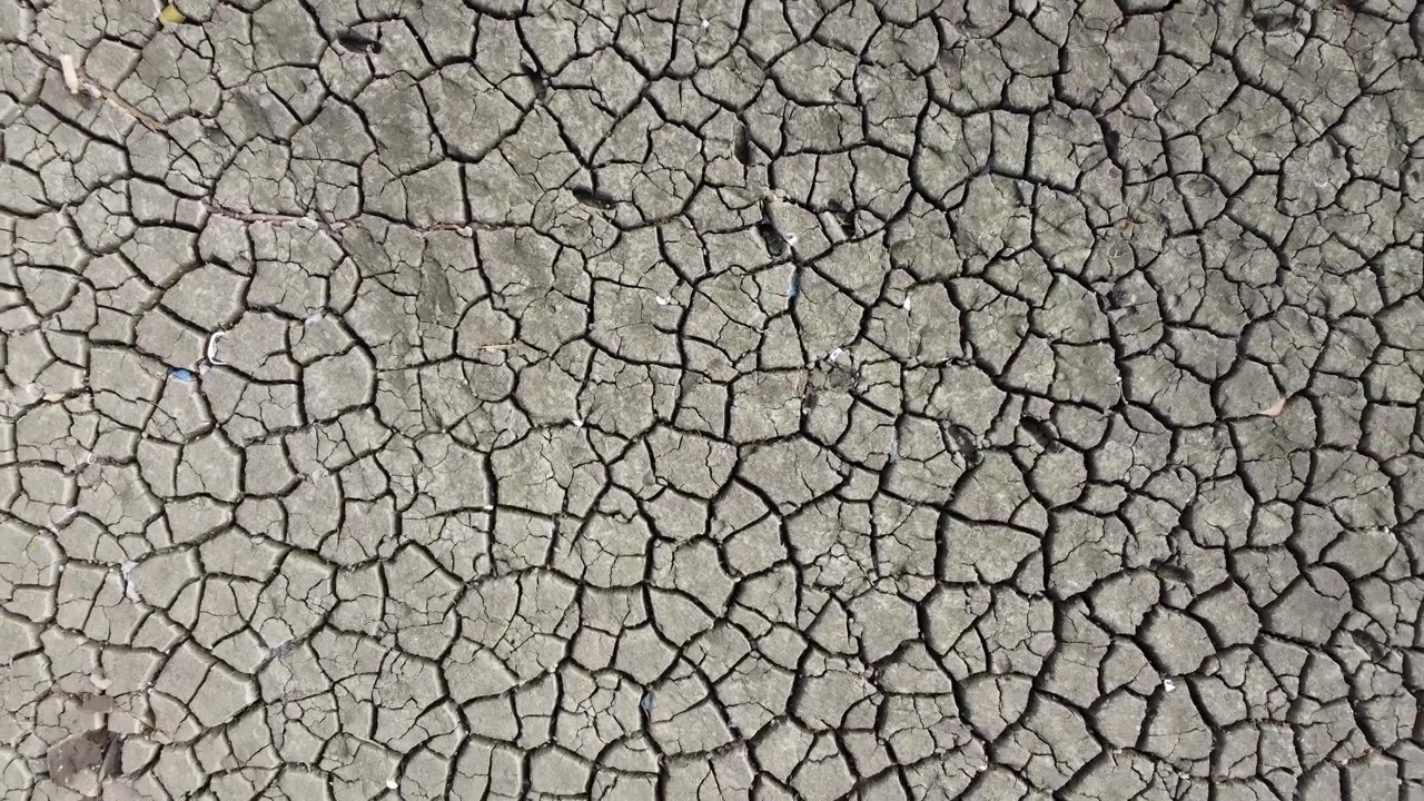 An aerial view of the dried up and cracked earth lake bed exposed by heat wave and drought conditions.