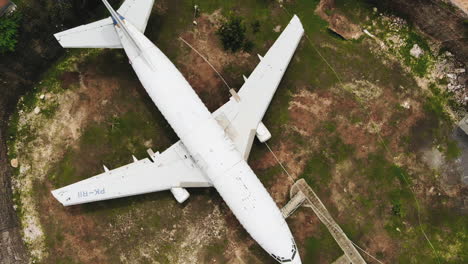 descending aerial top down view of the abandoned airplane in bali, indonesia