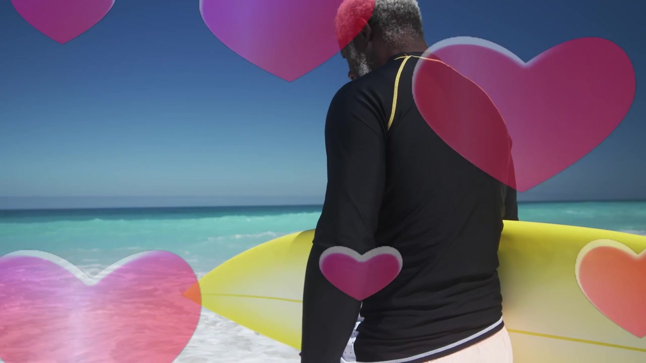 Dojrzały mężczyzna idący w stronę oceanu w celach sportowych z żółtą deską surfingową, różowe serca unoszące się nad postacią.