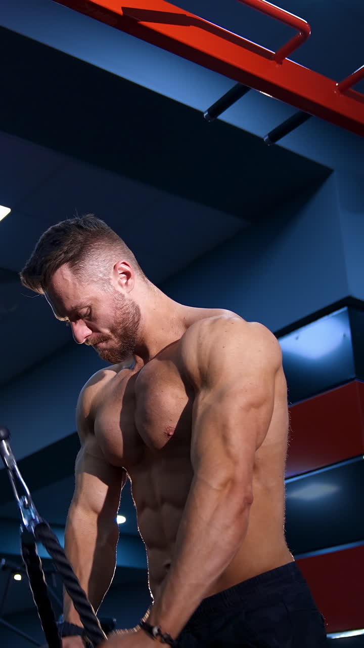Exercise for triceps in the gym. Handsome muscular man working out at gym. Vertical video