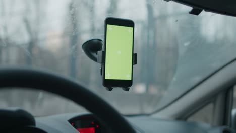 movimiento de deslizamiento y toque con pantalla verde chroma key ready smartphone conectado en el parabrisas del coche en cámara lenta