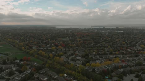 aerial footage facing towards downtown ottawa with views of huge city buildings in the distance as well as the ottawa river and some sub-divisions and a train track in the foreground