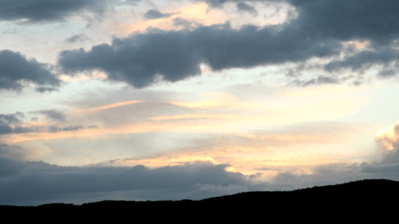 금색과 주황색 하늘이 먹구름 아래 가려지면서 색상이 더욱 강해집니다.