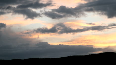 Ein-Goldener-Und-Orangefarbener-Himmel-Intensiviert-Sich,-Da-Er-Von-Dunklen-Wolken-Verdeckt-Wird