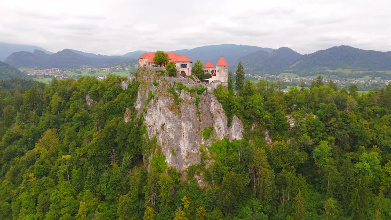 Riprese con drone mostrano lo splendido Castello di Bled, arroccato su una scogliera sopra il lago turchese, circondato dal paesaggio mozzafiato della Slovenia.