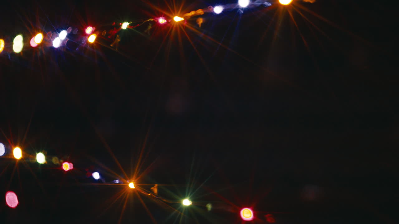 String of Christmas lights flashing at night with copy space in the center