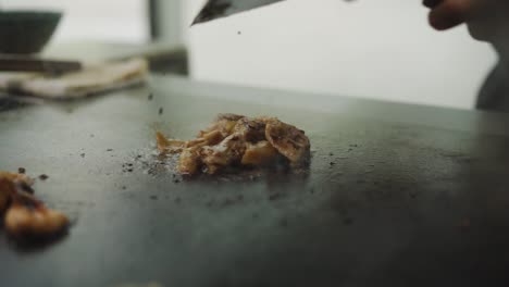 chef pour soy sauce on meat cooking in hot iron griddle in teppanyaki restaurant