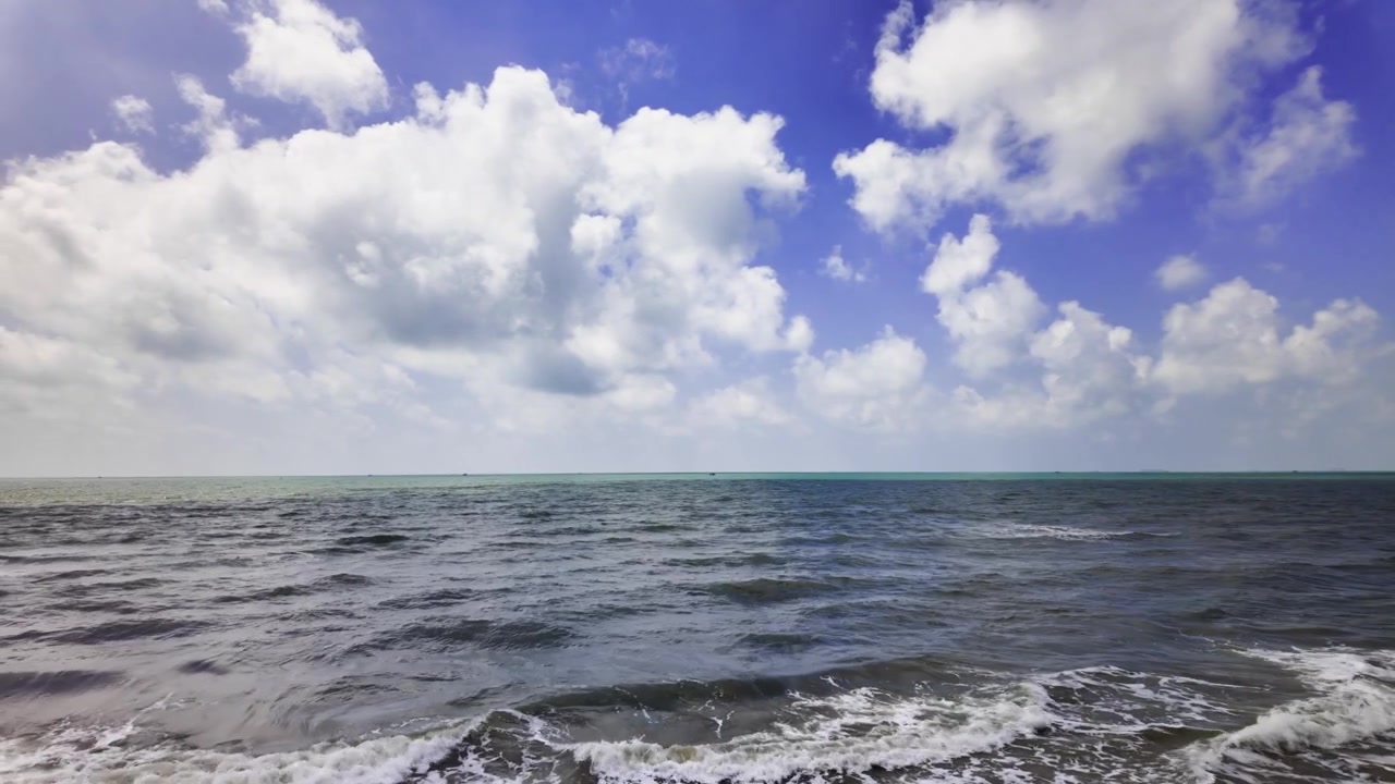 A Bai Tam Nong Noc a Vung Tau, Vietnam, un casco e un supporto per fotocamera si trovano sulla riva. Le onde si infrangono mentre le persone si godono la spiaggia e il sole in questo luogo