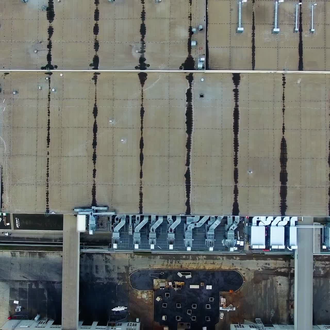 Industrial territory. Flight over the roofs of a plant. Manufacturing. Many buildings connected together of a large factory. Aerial view.
