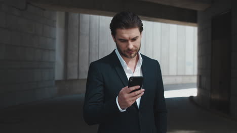 Businessman-using-smartphone-on-street.-Manager-texting-on-mobile-phone-in-city