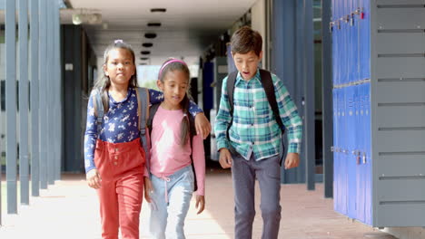 in school, three young biracial students are walking together