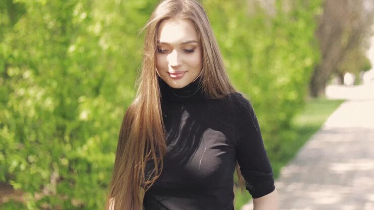 Side view of pretty woman posing sensually and smiling at camera