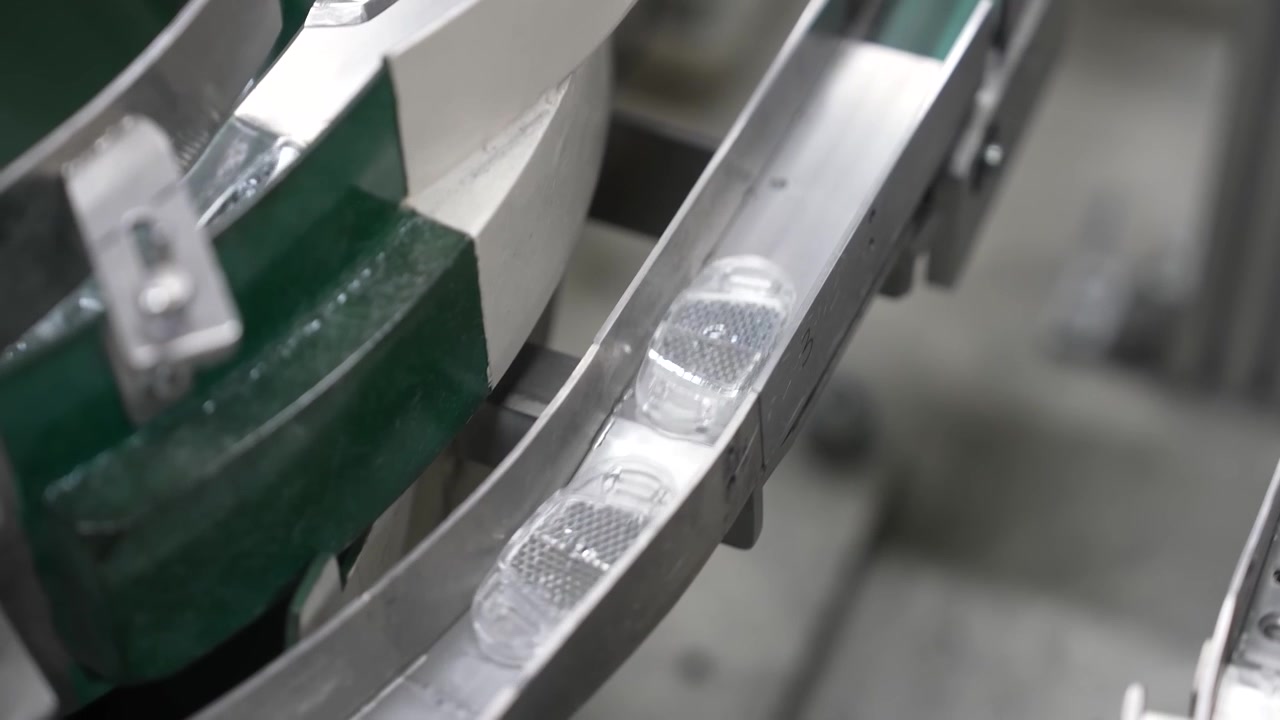 Molded parts circulating on the rim of a green vibratory bowl feeder