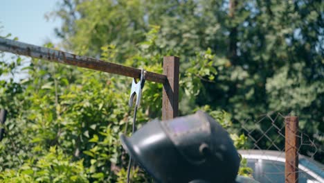 backside-view-builder-puts-clamp-on-part-of-metal-fence