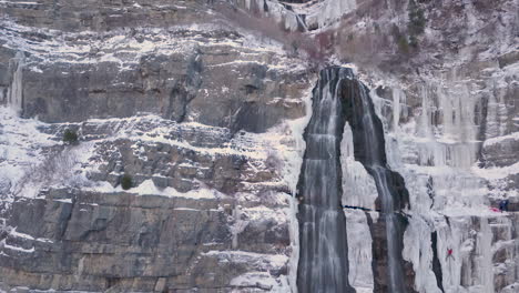 ice climbers hang dangerously from a frozen waterfall in the rocky mountains - sliding up