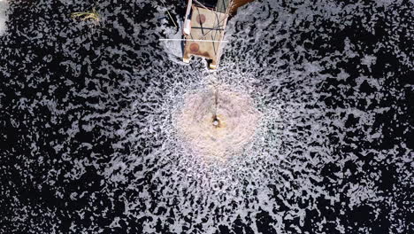 top down aerial footage of a water aerator in a byproduct pool of an industrial paper plant